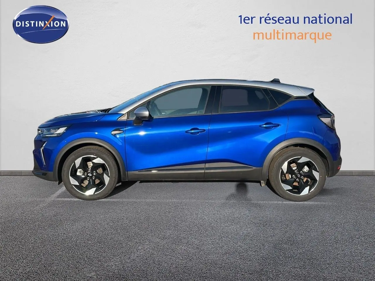 Profil latéral gauche d'un Renault Captur E-Tech hybride bleu Iron avec toit gris, jantes noires et détails modernes.