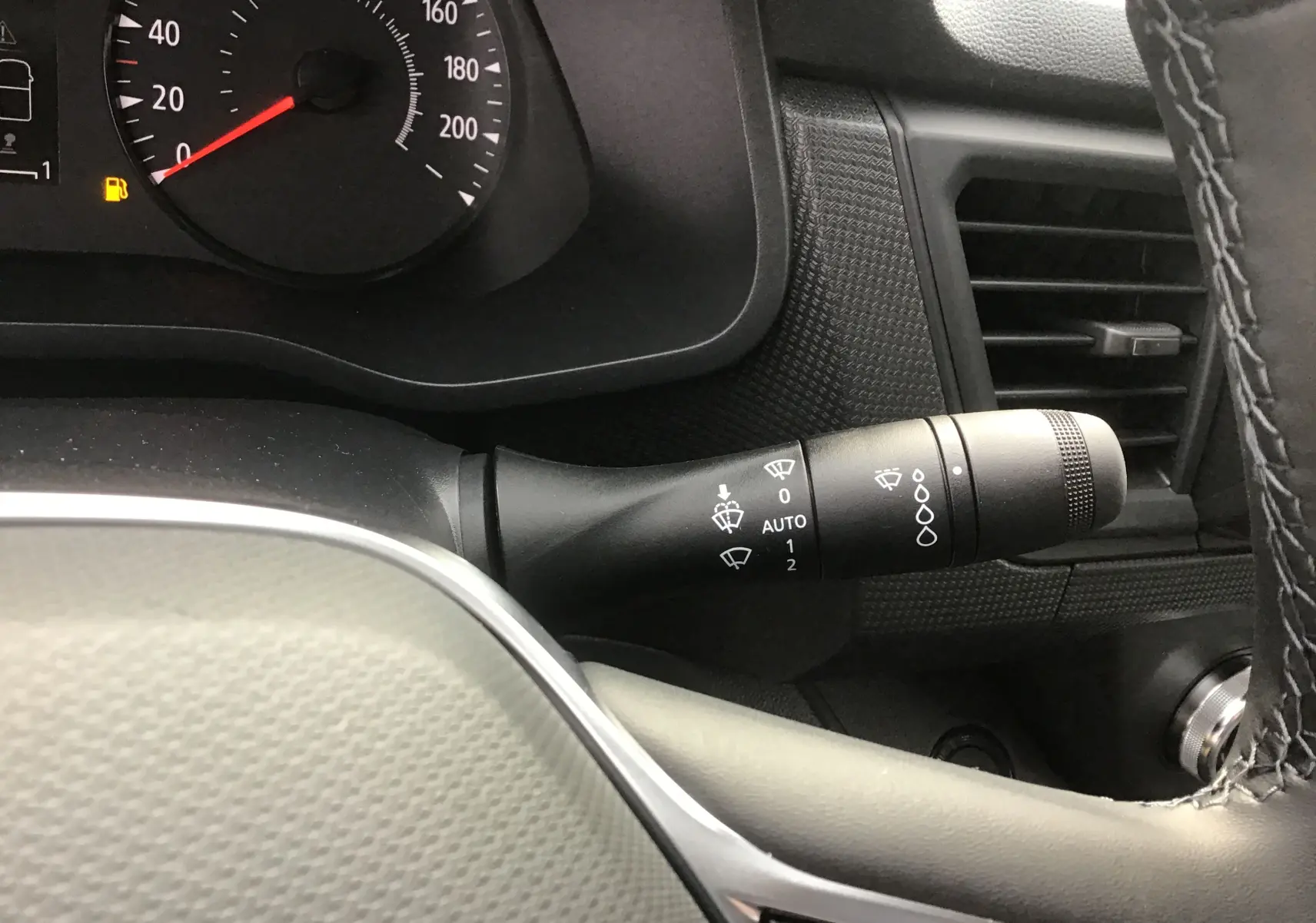 Gros plan sur la manette de commande des essuie-glaces du tableau de bord du Renault Trafic Fourgon gris urbain 2025.