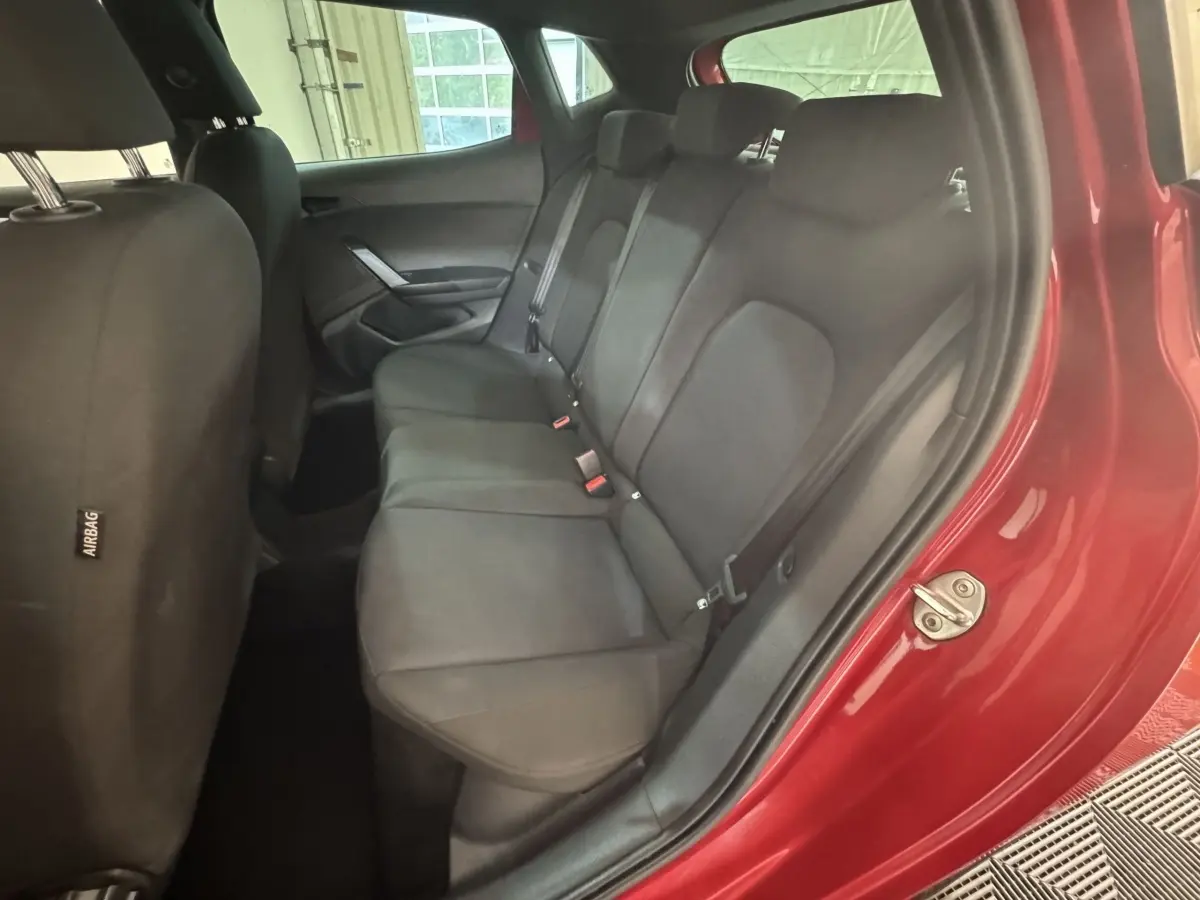 Vue intérieure côté arrière droit sur la banquette noire d'une SEAT IBIZA 1.0 TSI 110 FR rouge 2024.