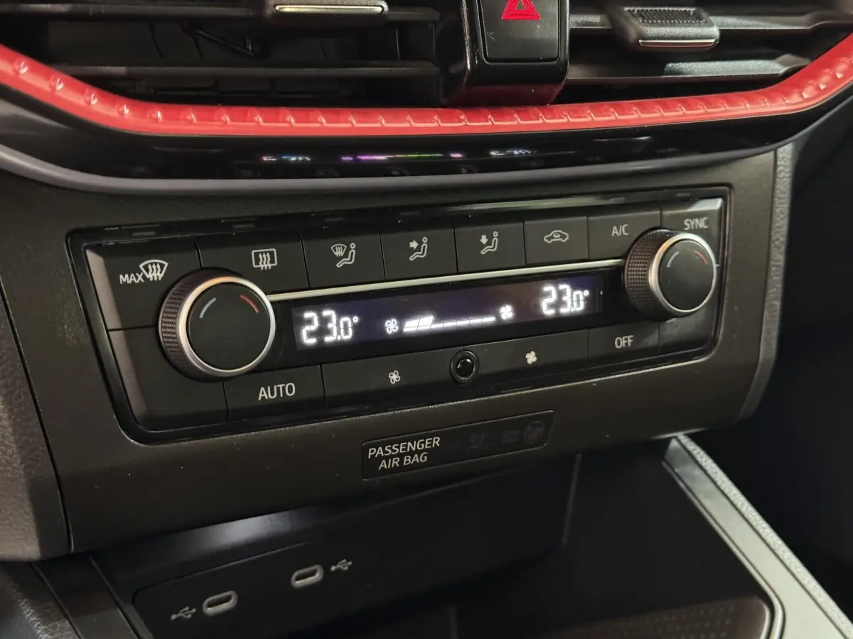 Gros plan sur la commande de climatisation digitale bicolore noir et rouge de la SEAT IBIZA 1.0 TSI 110 FR 2024.