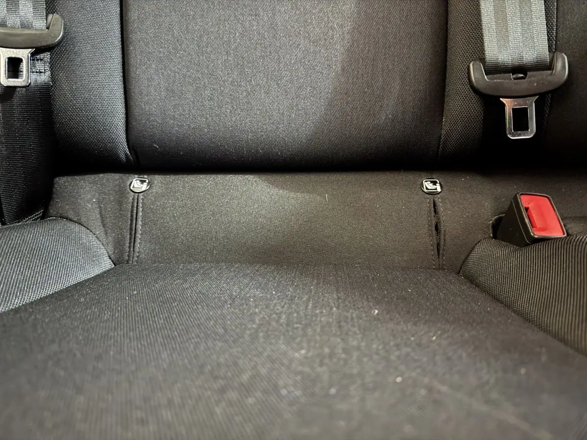 Gros plan sur la banquette arrière noire de la SEAT Ibiza 1.0 TSI 110 FR 2024, montrant les attaches Isofix et la boucle de ceinture.