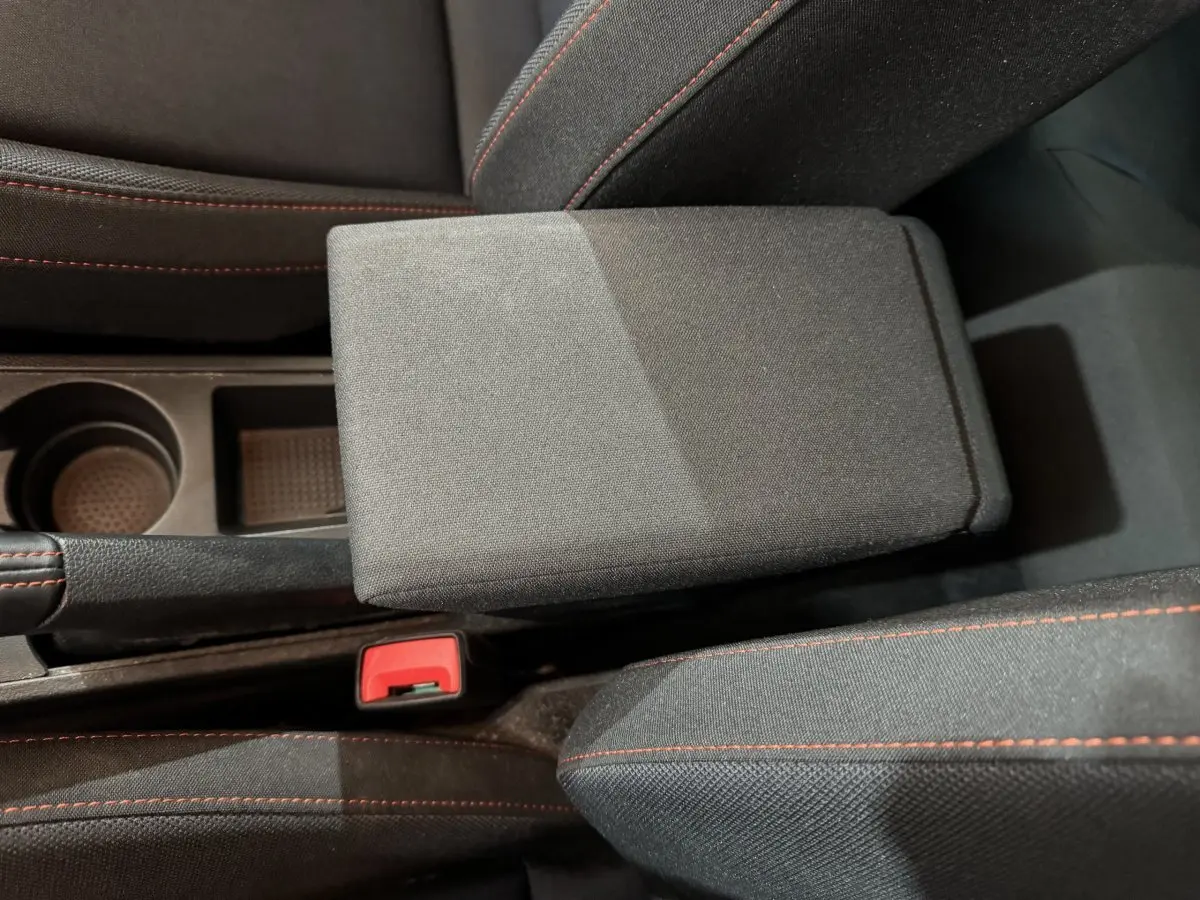 Gros plan sur l'accoudoir central noir avec surpiqûres rouges dans l'habitacle d'une SEAT IBIZA 1.0 TSI 110 FR rouge 2024