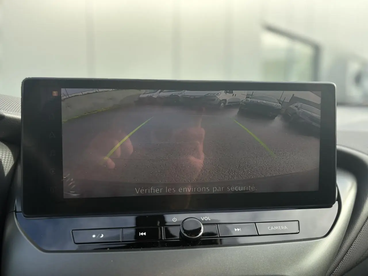 Écran tactile du système de navigation NissanConnect montrant la caméra de recul du Nissan Juke gris foncé, vue intérieure avant.