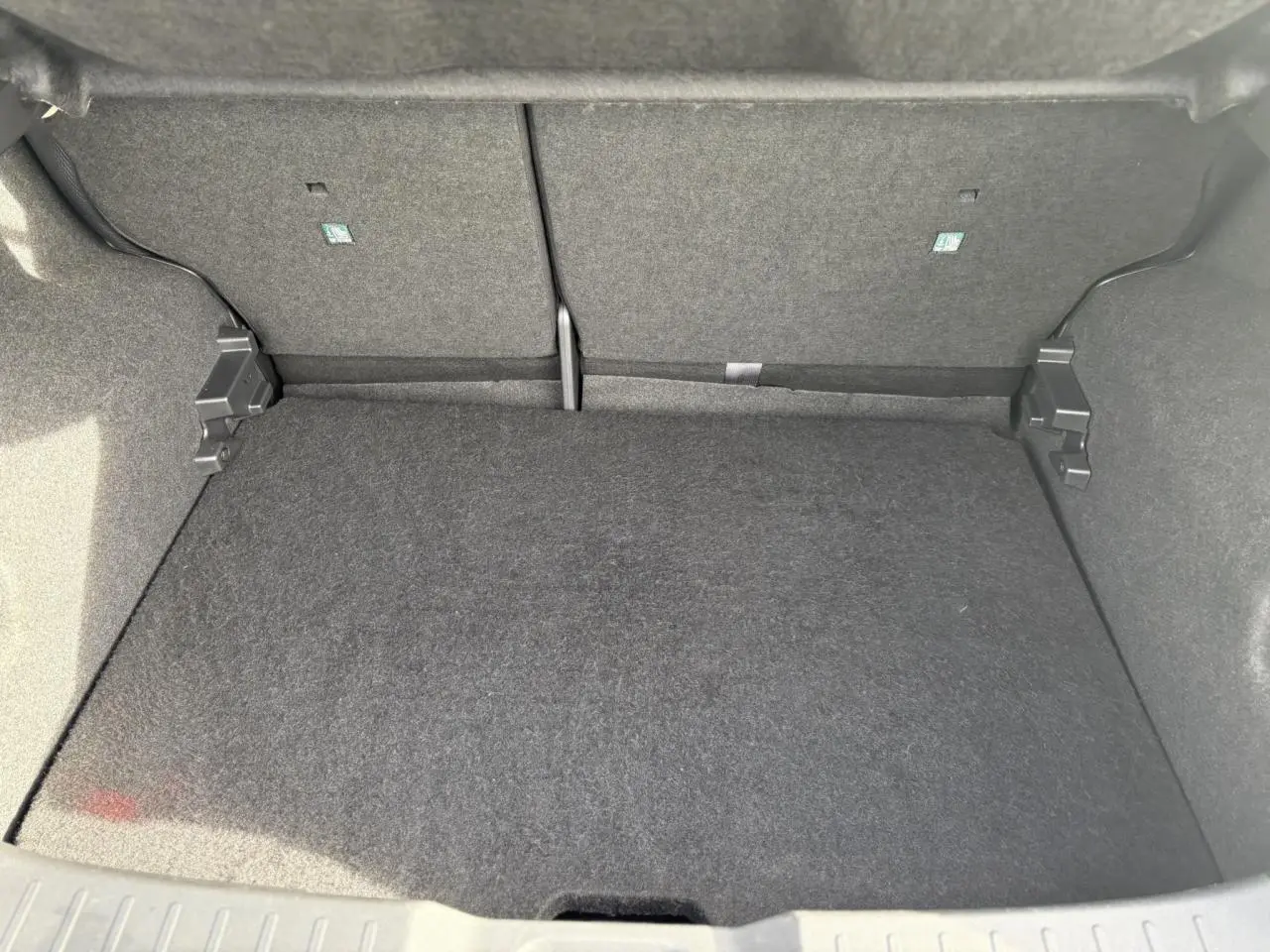 Coffre modulable du Nissan Juke 2025 en vue intérieure, revêtement gris foncé uniforme et propre.