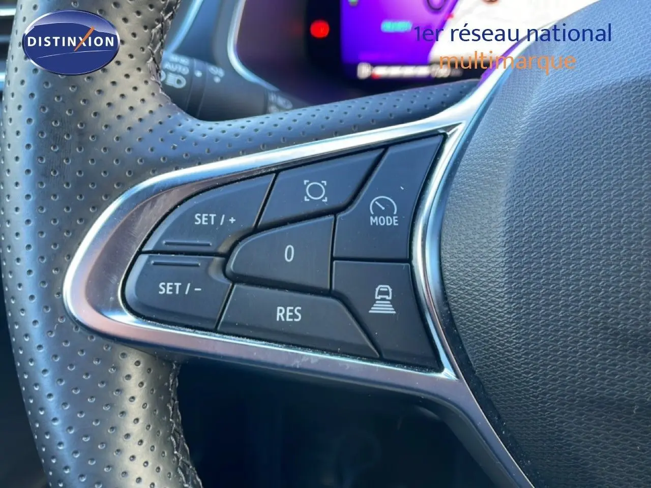 Gros plan sur les commandes au volant en cuir perforé de la Renault Symbioz bleu iron metal, version hybride 2025.