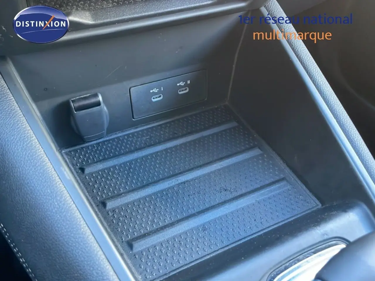 Gros plan sur la console centrale noire du Renault Symbioz 2025, montrant deux ports USB-C et un espace de rangement texturé.