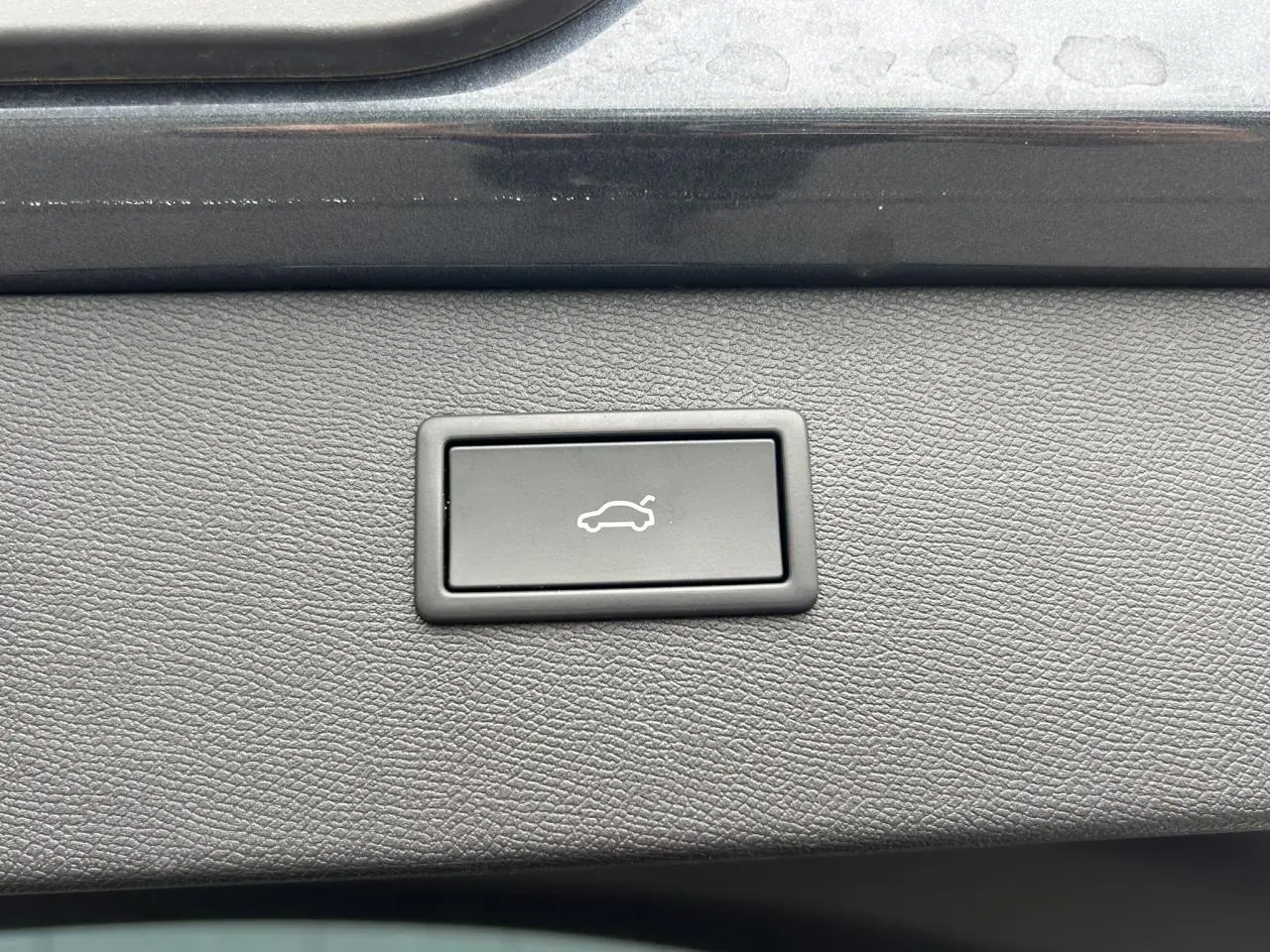 Bouton de déverrouillage du hayon sur panneau intérieur gris d’un CUPRA Formentor 2025.
