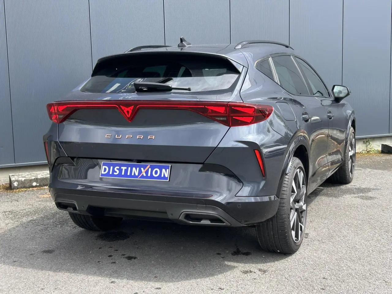 Vue 3/4 arrière droite d'une CUPRA Formentor gris magnétique avec feux arrière Tri-LED et jantes alliage 19 pouces.