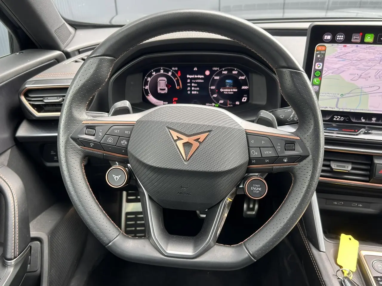Vue rapprochée du volant cuir perforé noir avec logo CUPRA cuivre et tableau de bord digital du Formentor gris magnétique.
