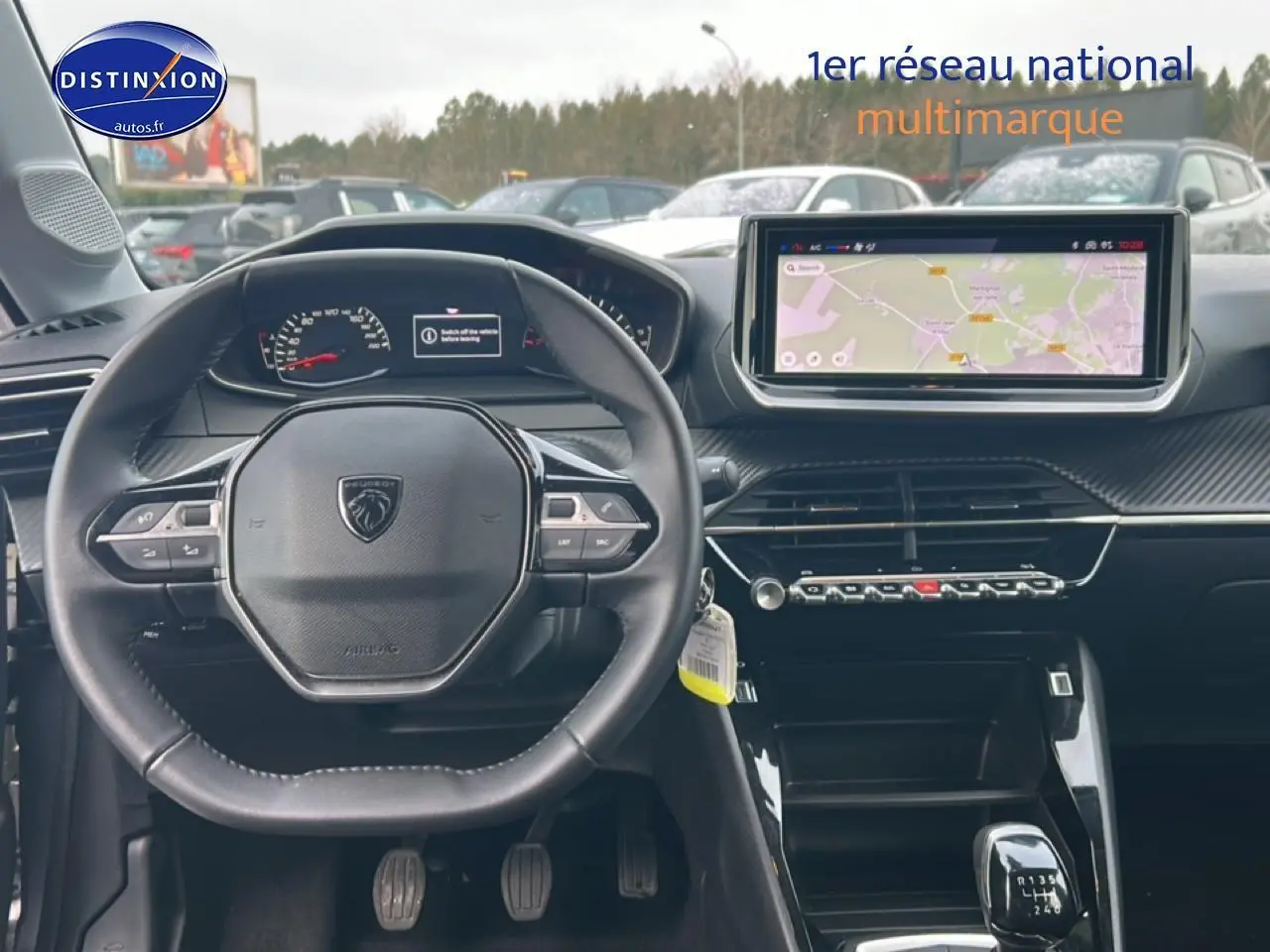 Vue intérieure frontale du poste de conduite de la Peugeot 208 gris Artense avec écran tactile et volant compact.