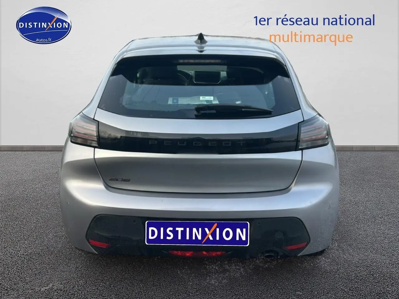 Vue arrière d'une Peugeot 208 gris artense 2025 avec feux arrière sombres et logo Peugeot central sur hayon.