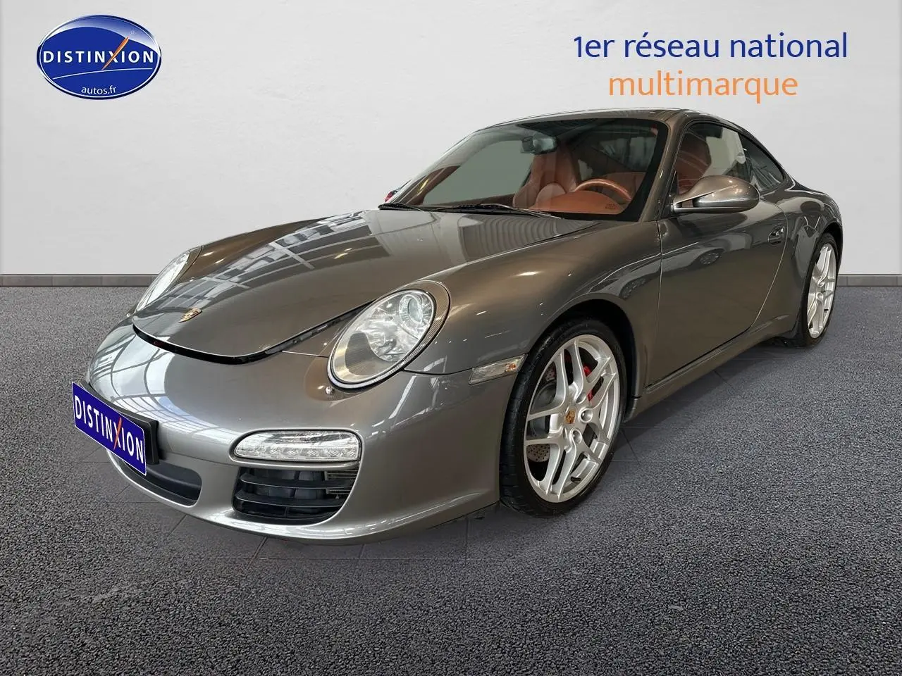 Porsche 911 (997) Carrera PDK gris vue 3/4 avant droit avec jantes alu et intérieur cuir marron visible.