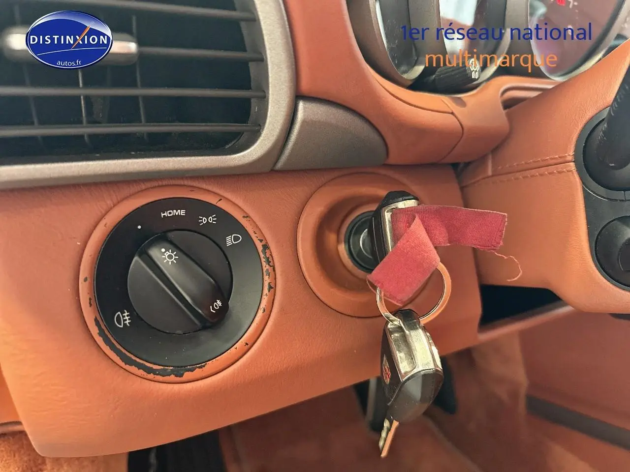 Gros plan sur le contacteur de clé dans l'habitacle cuir marron d'une Porsche 911 (997) carrera pdk de 2009.