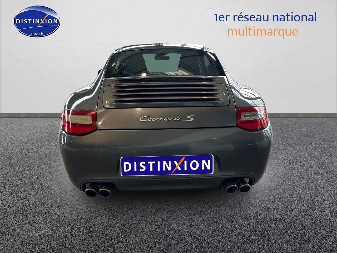 Vue arrière d'une Porsche 911 (997) Carrera S gris métallisé avec double sortie d'échappement et feux rouges.