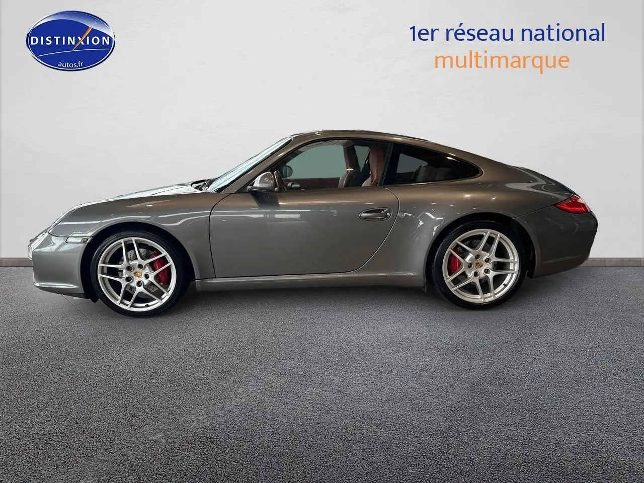 Profil côté gauche d'une Porsche 911 (997) Carrera PDK gris métallisé avec jantes alu et étriers rouges.