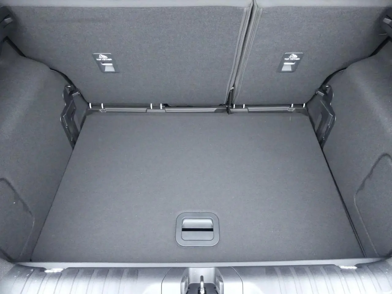 Coffre spacieux vu de dessus du Ford Puma 2025 gris métallisé avec plancher plat et compartiments latéraux.