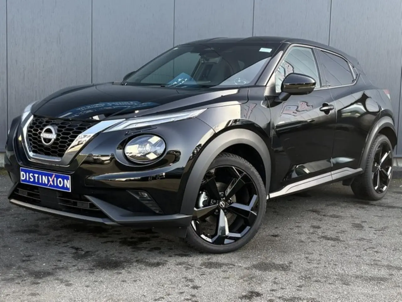 Nissan Juke 2024 noir Black Pearl en 3/4 avant droit avec jantes alliage noires et calandre chromée.