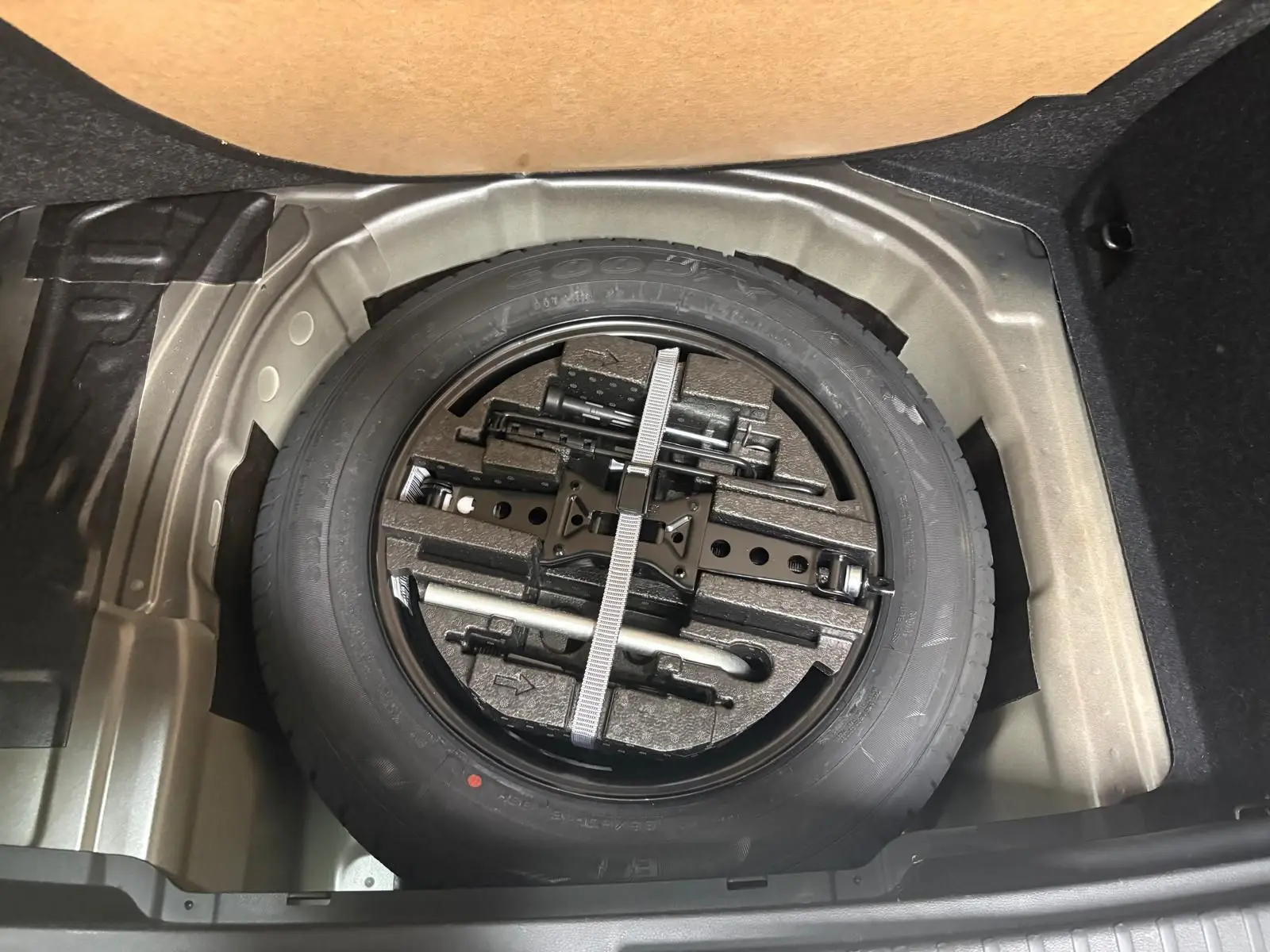 Roue de secours avec outils de bord dans le coffre d’un Skoda Kamiq 2023, vue plongeante sur le compartiment.