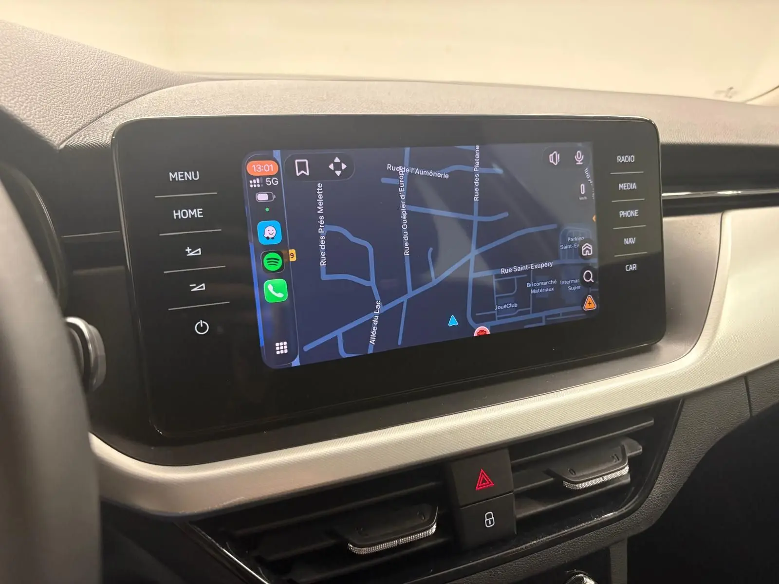 Écran tactile central du Skoda Kamiq 2023 affichant la navigation, avec commandes tactiles sur les côtés.