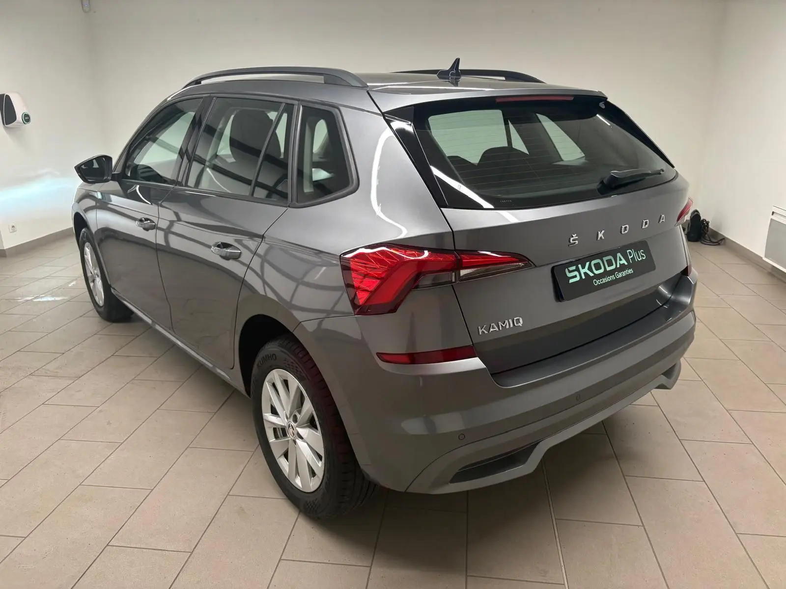 Vue 3/4 arrière droite d'un Skoda Kamiq 2023 gris graphite métallisé, avec feux arrière LED et toit noir contrasté.