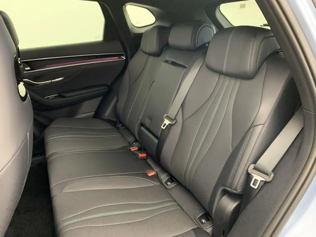 Vue intérieure arrière droite du BYD SEAL U 2025 en Tian Qing, sièges noirs avec surpiqûres et ceintures grises.