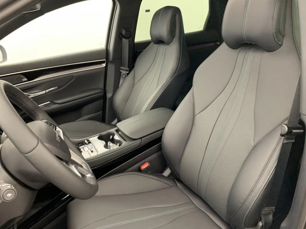 Vue intérieure côté conducteur du BYD SEAL U 1.5 DM-i 2025, sièges noir et brun avec volant en similicuir vegan.