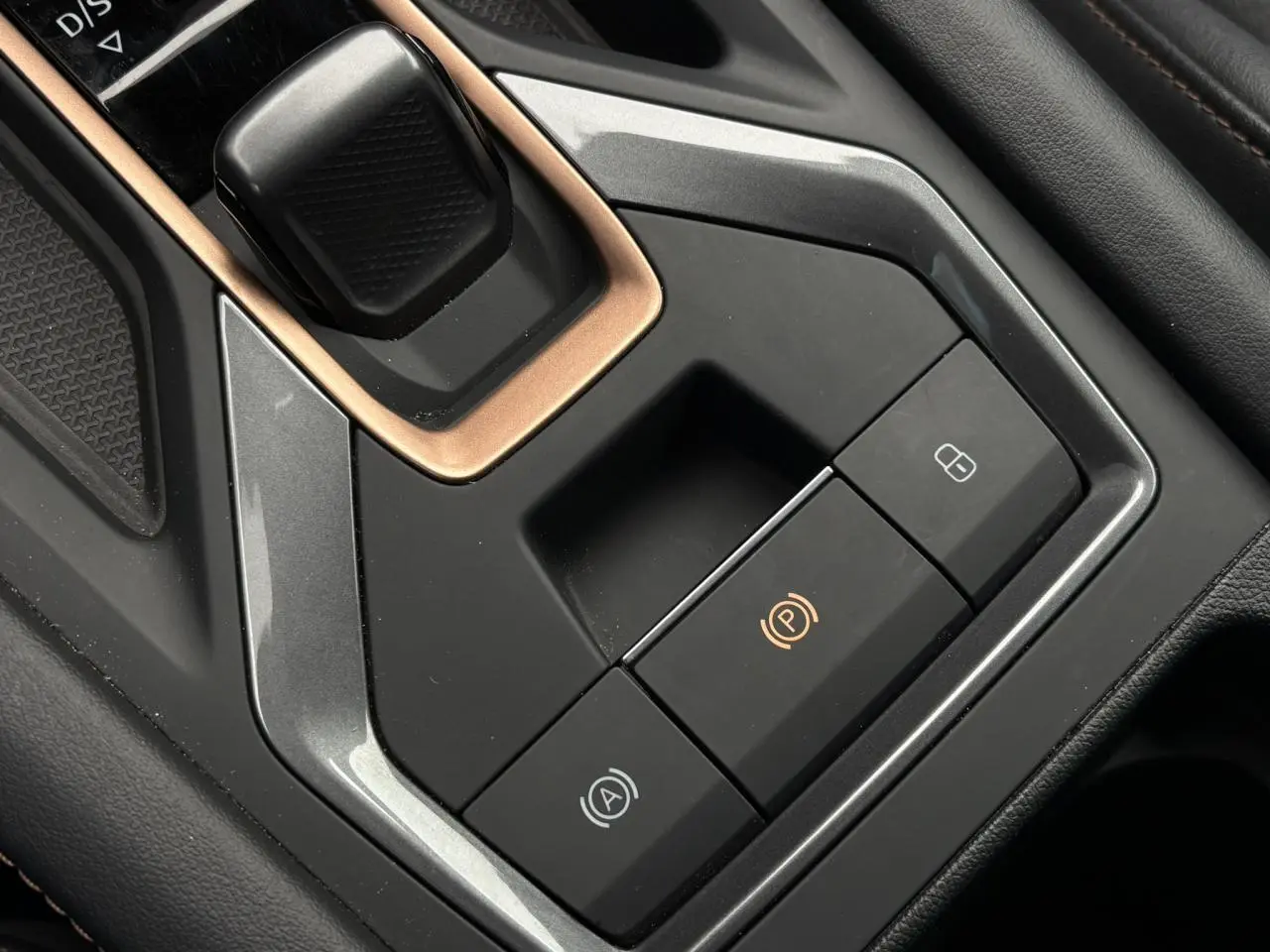 Gros plan sur la console centrale noire du CUPRA Formentor avec boutons de frein à main électrique et verrouillage.