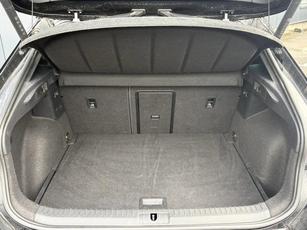 Coffre ouvert vu de l'arrière d'un CUPRA Formentor Noir Minuit avec intérieur de coffre en tissu gris.