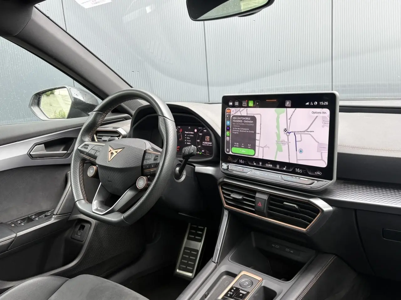 Vue intérieure côté conducteur du CUPRA Formentor noir Minuit, avec volant multifonction et écran tactile de navigation visible.