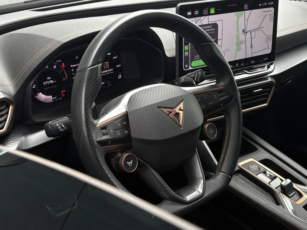 Vue rapprochée du volant cuir perforé noir avec logo CUPRA cuivré et tableau de bord numérique du Formentor 2025.