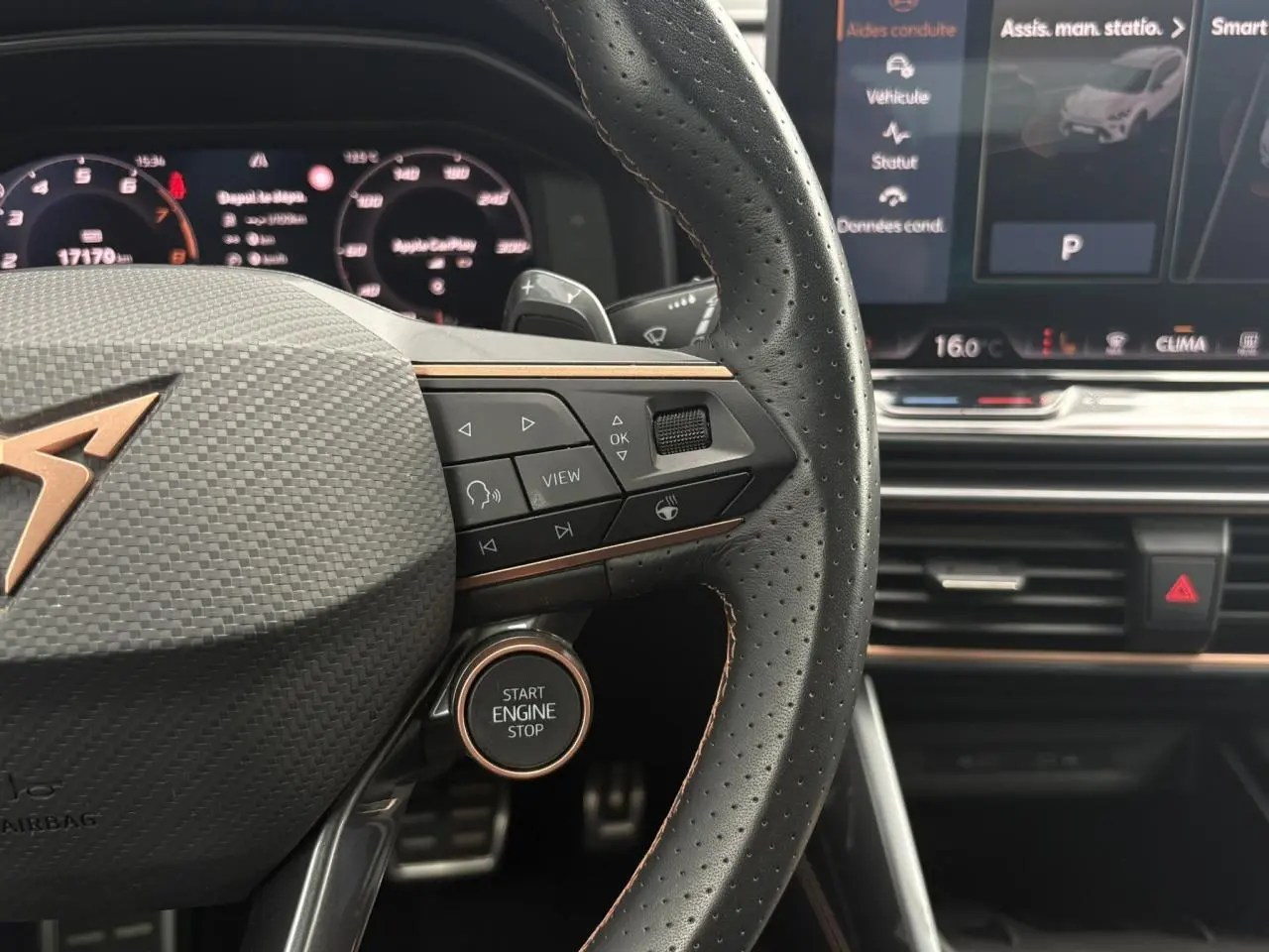 Gros plan sur le volant cuir perforé noir du CUPRA Formentor avec boutons multifonctions et bouton start engine stop.