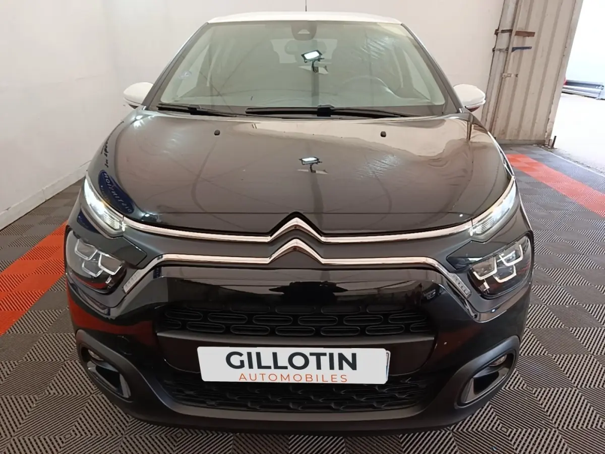 Vue frontale d'une Citroën C3 noire 2022 avec phares LED et calandre chromée dans un garage.