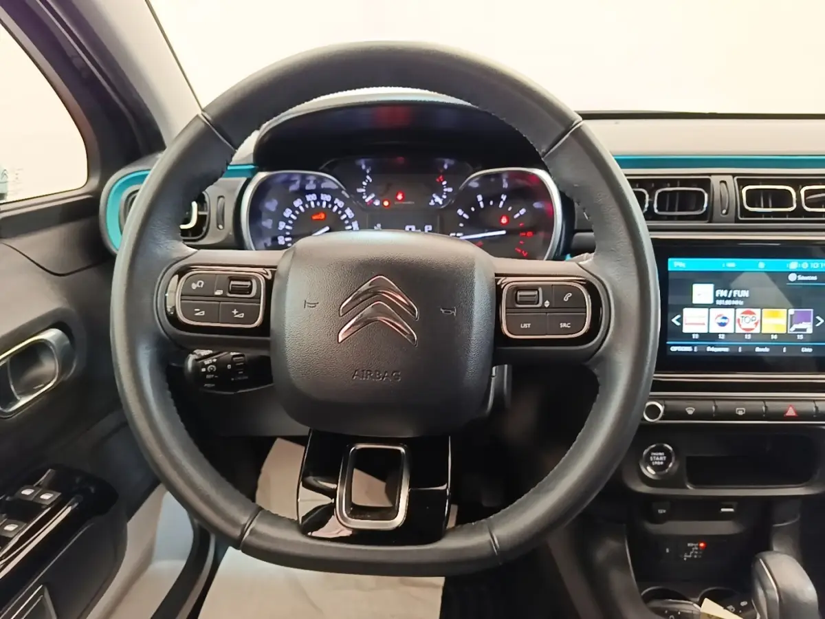 Vue intérieure centrée sur le volant cuir noir de la Citroën C3 2022 avec tableau de bord et écran tactile.