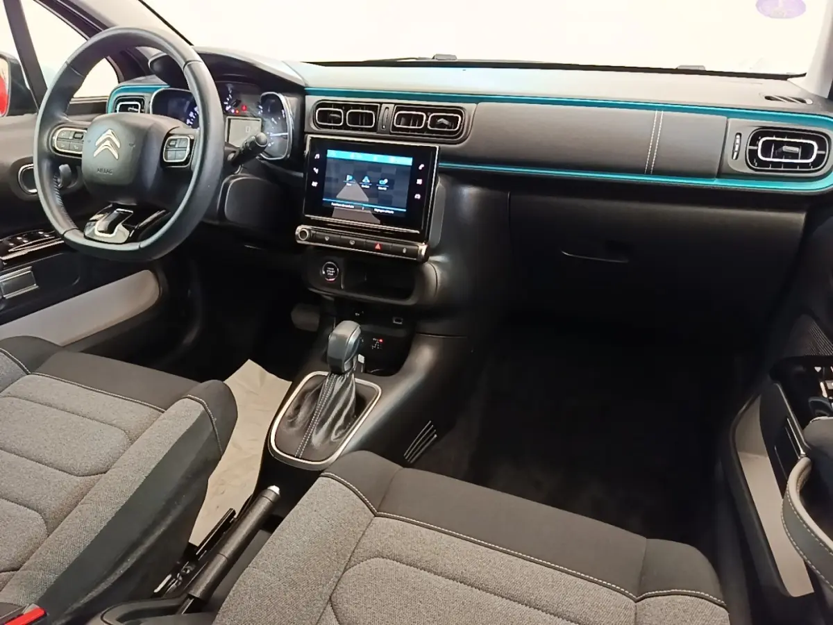 Vue intérieure avant droite du tableau de bord noir et gris de la Citroën C3 avec écran tactile et volant cuir.