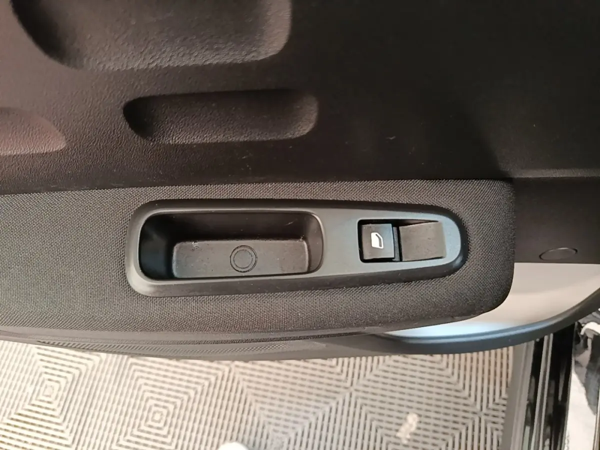 Gros plan sur la commande de lève-vitre côté gauche de la porte d’une Citroën C3 noire 2022.