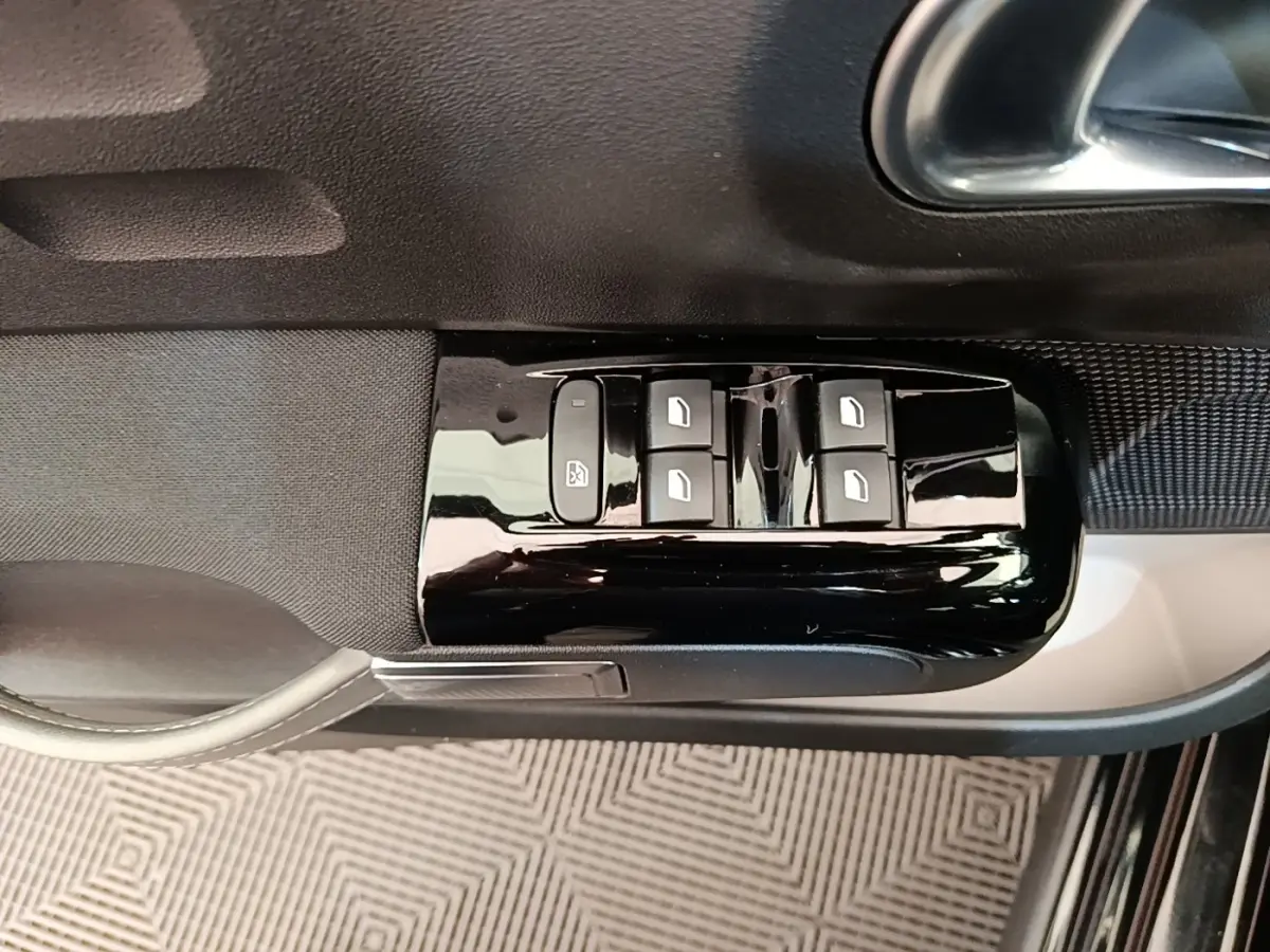 Gros plan sur les commandes de lève-vitres côté conducteur de la Citroën C3 noire, finition Shine Pack 2022.