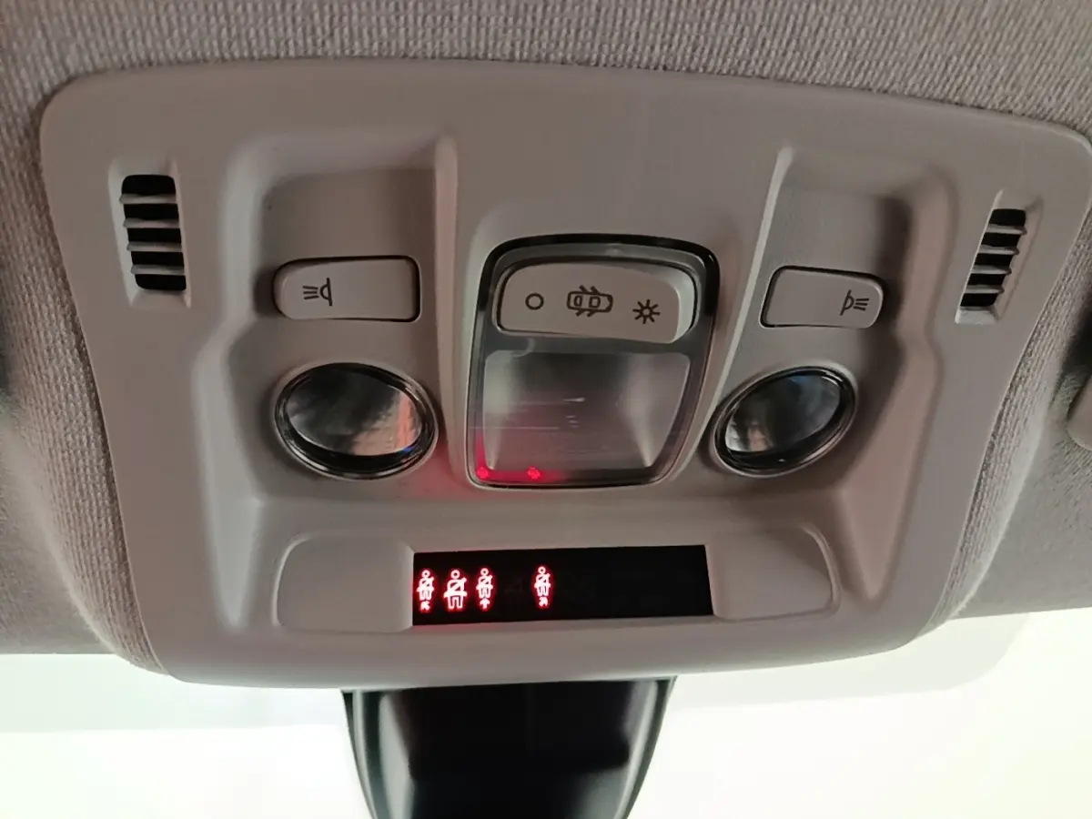 Gros plan sur la console de plafonnier avec éclairages et indicateurs de ceinture dans une Citroën C3 noire 2022.