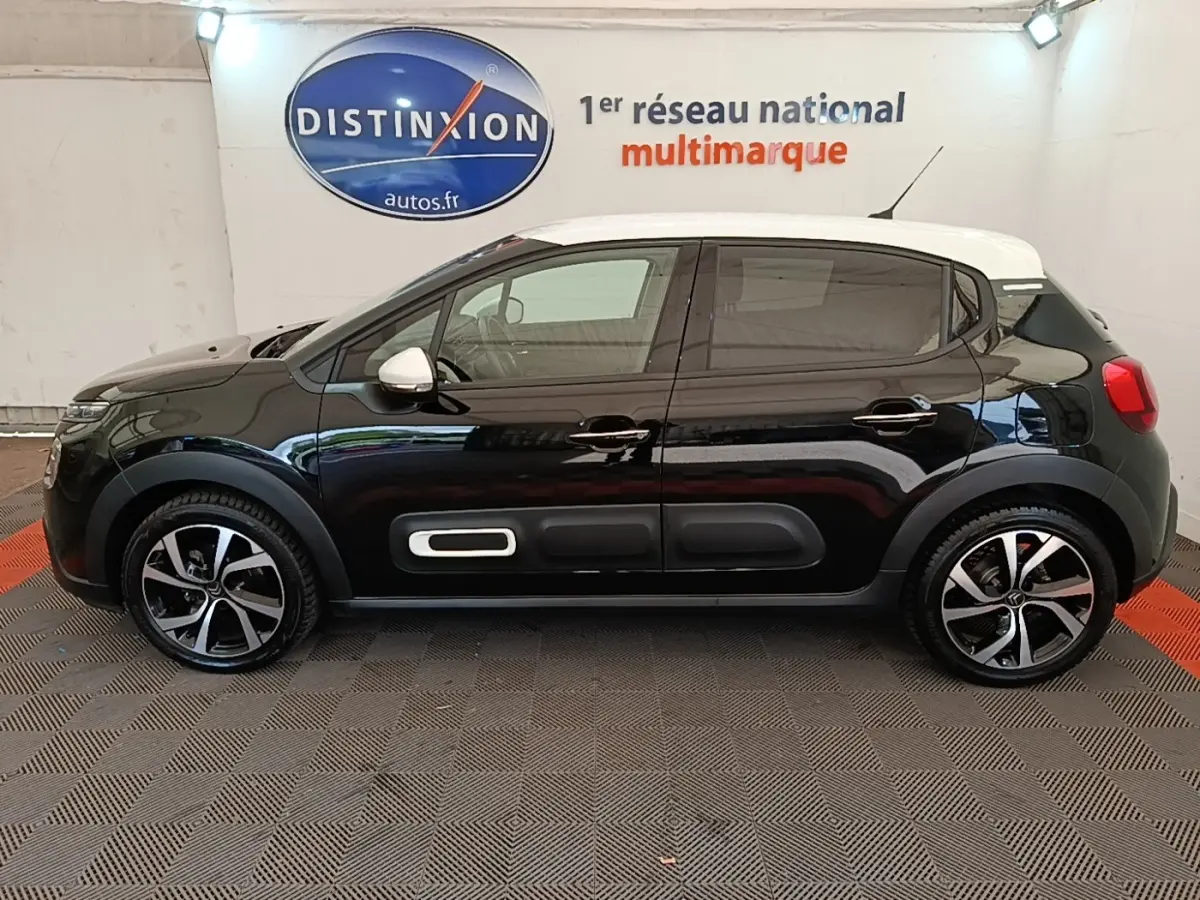 Profil droit d'une Citroën C3 PureTech 110 noire avec toit blanc et protections latérales caractéristiques.