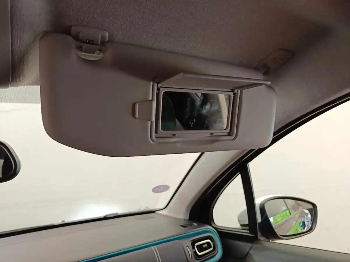 Détail intérieur du pare-soleil avec miroir ouvert côté conducteur de la Citroën C3 noire, vue depuis l'habitacle avant.