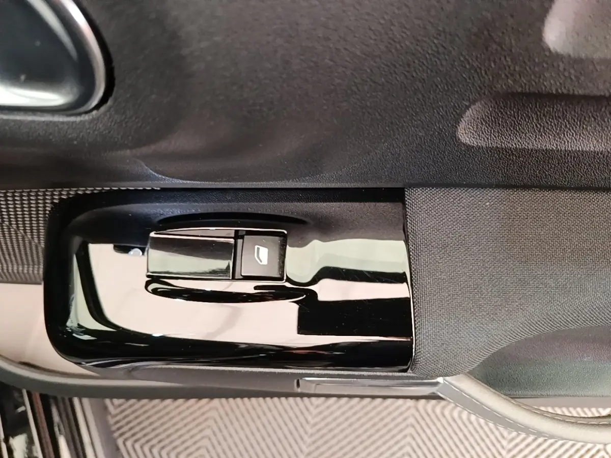 Gros plan sur la commande de lève-vitre côté conducteur de la Citroën C3 noire, finition Shine Pack 2022.