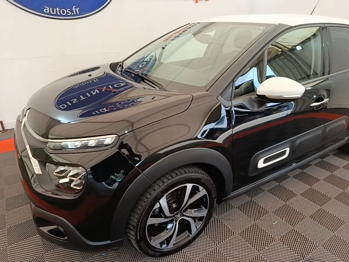 Vue 3/4 avant droit d'une Citroën C3 noire avec rétro blanc et jantes alliage distinctives.