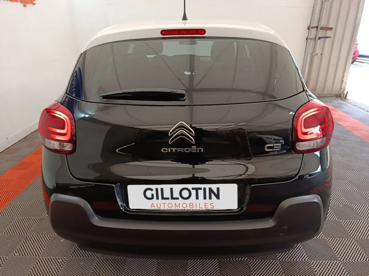 Vue arrière d'une Citroën C3 noire 2022 avec feux arrière LED allumés dans un garage fermé.