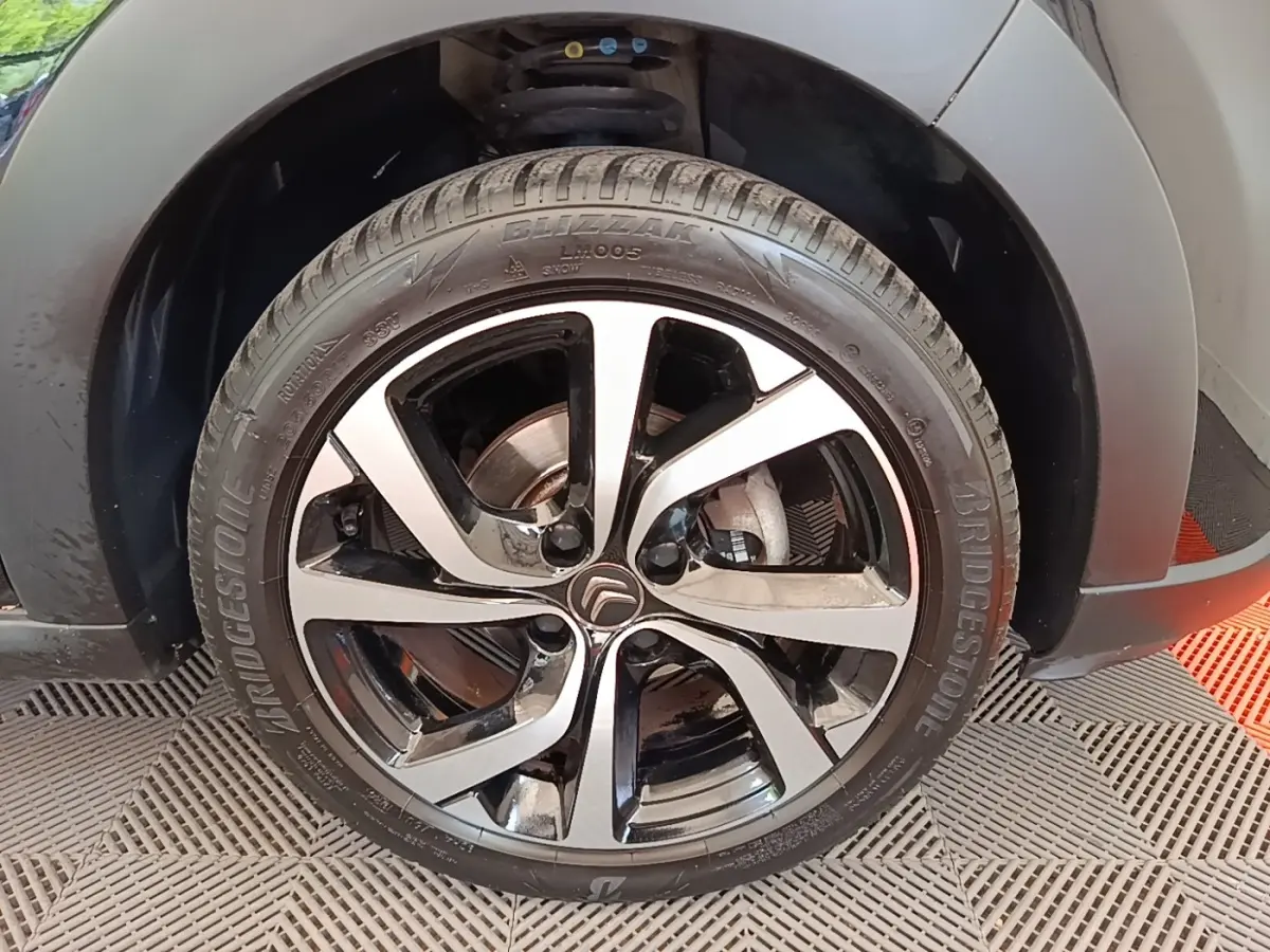Gros plan sur la roue avant droite noire avec jante alliage bicolore du Citroën C3 PureTech 110 2022.