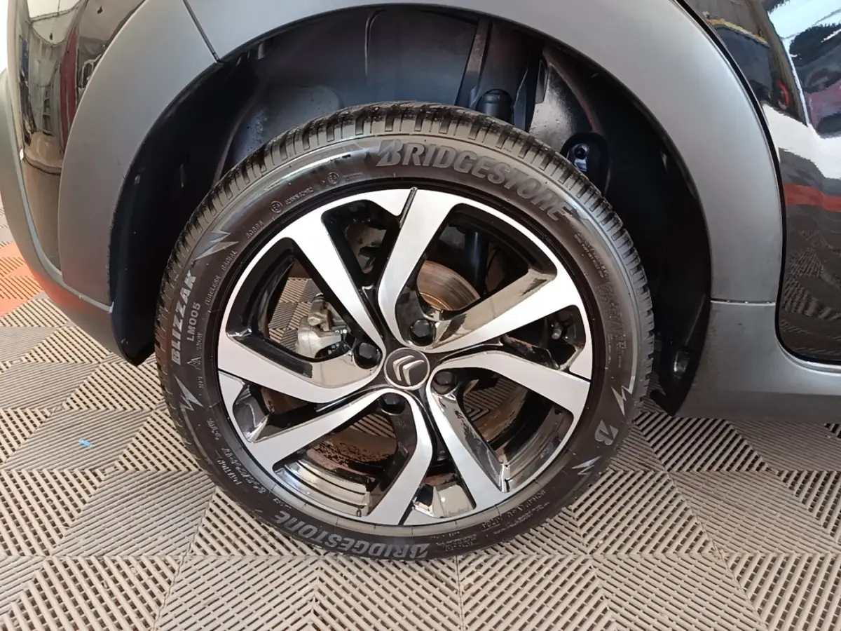 Gros plan sur la roue avant gauche noire d'une Citroën C3 2022 avec jante alliage et pneu Bridgestone.