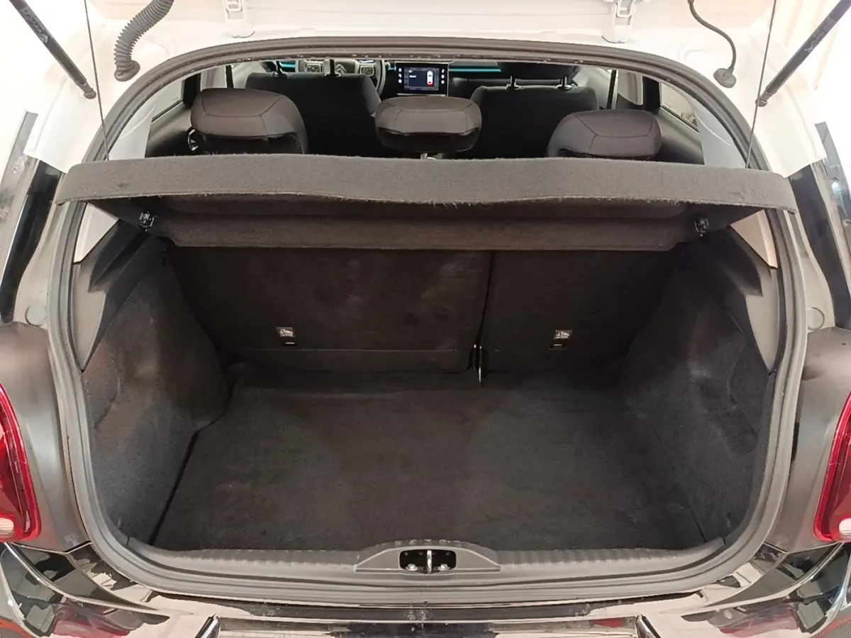 Vue arrière ouverte sur le coffre noir d'une Citroën C3 PureTech 110 Shine Pack 2022, intérieur et tablette de coffre visibles.