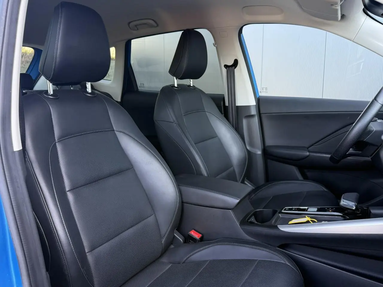 Vue intérieure côté conducteur du MG ZS 1.5 Hybrid+ 197 Luxury avec sièges similicuir noir et accoudoir central.