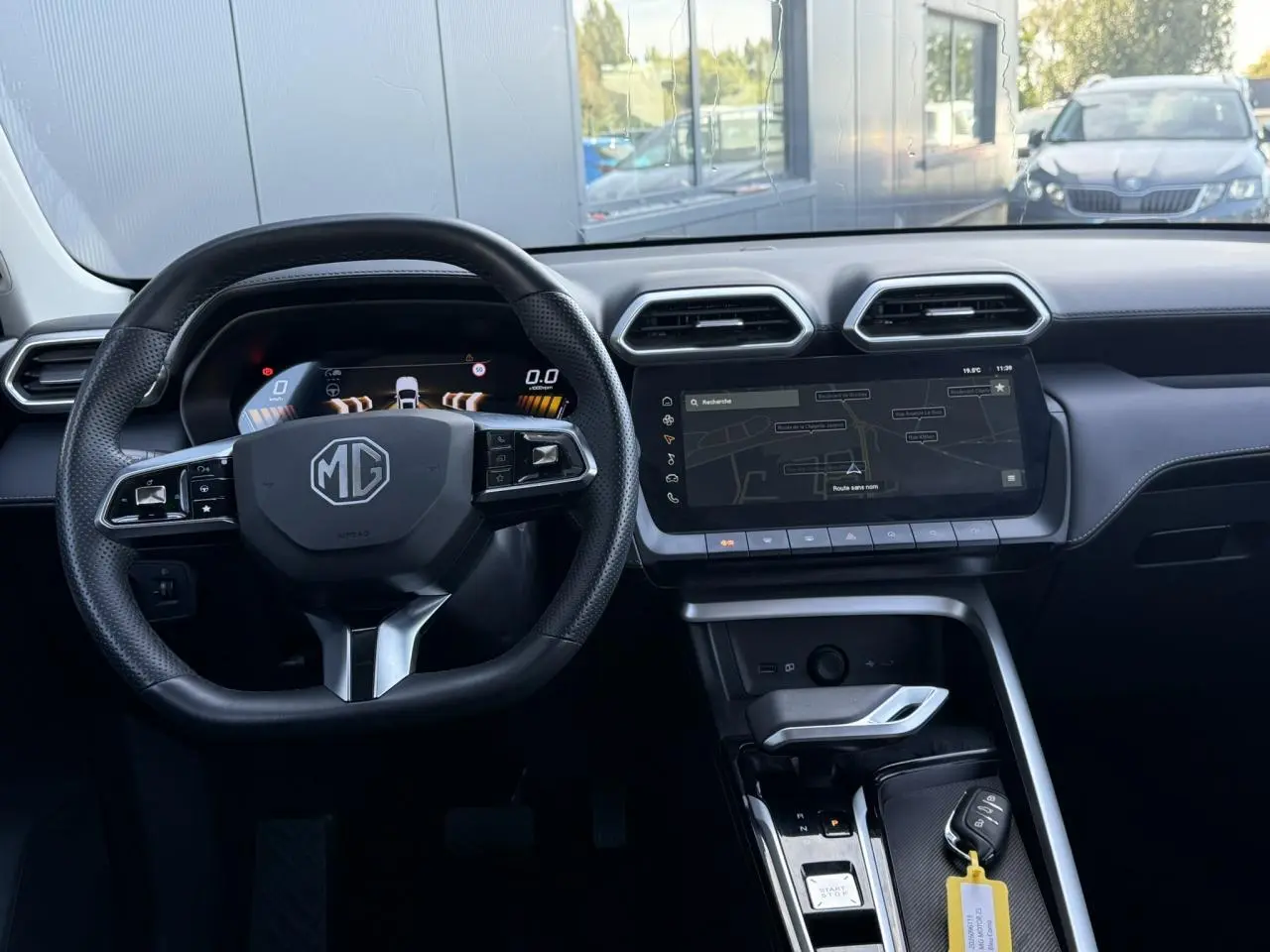 Vue intérieure frontale du poste de conduite du MG ZS 1.5 Hybrid+ 197 Luxury avec volant cuir noir et écran tactile 12,3 pouces.