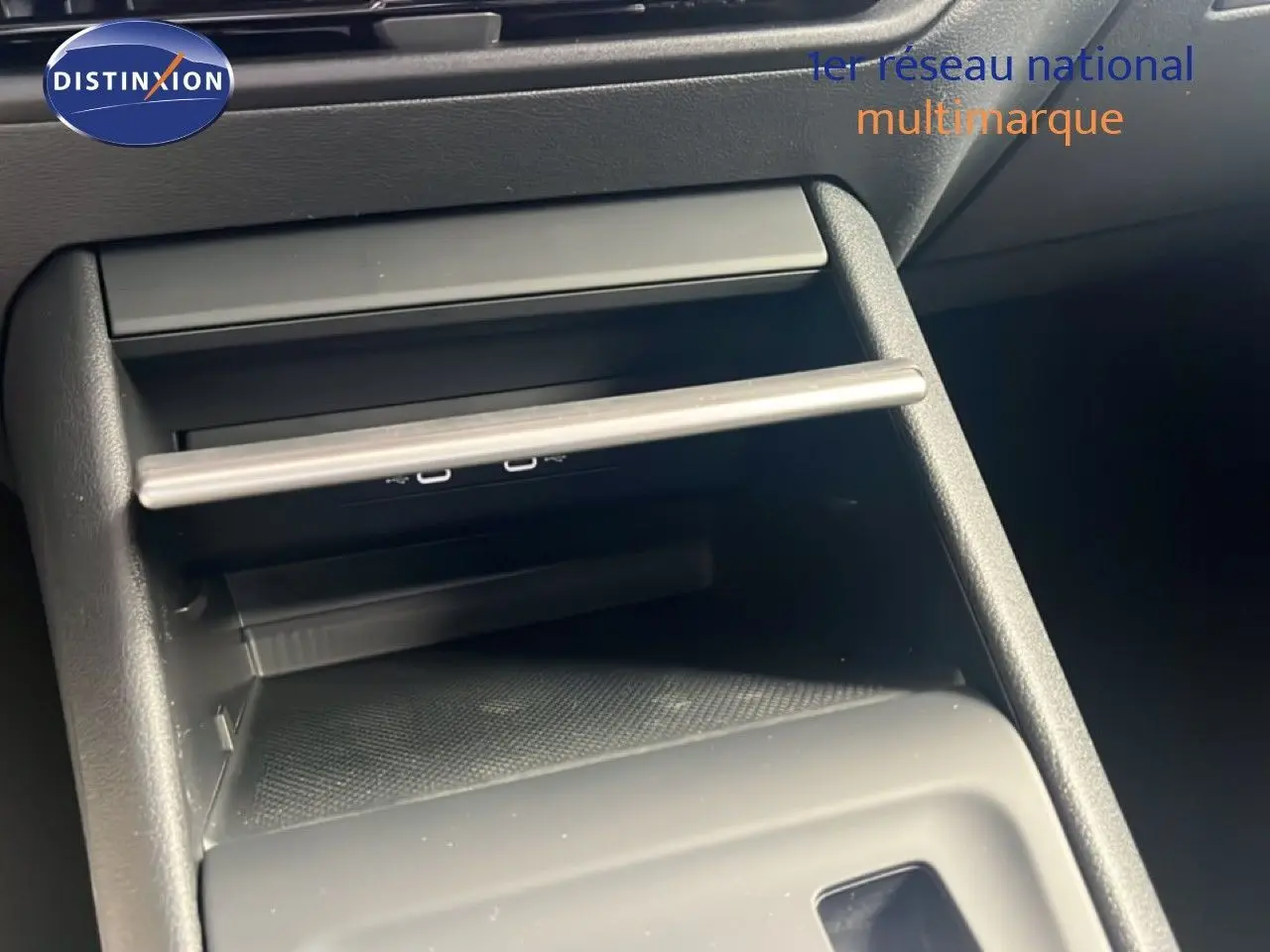 Gros plan sur la console centrale noire du Volkswagen Tiguan 2026, mettant en valeur les ports USB et le rangement intégré.
