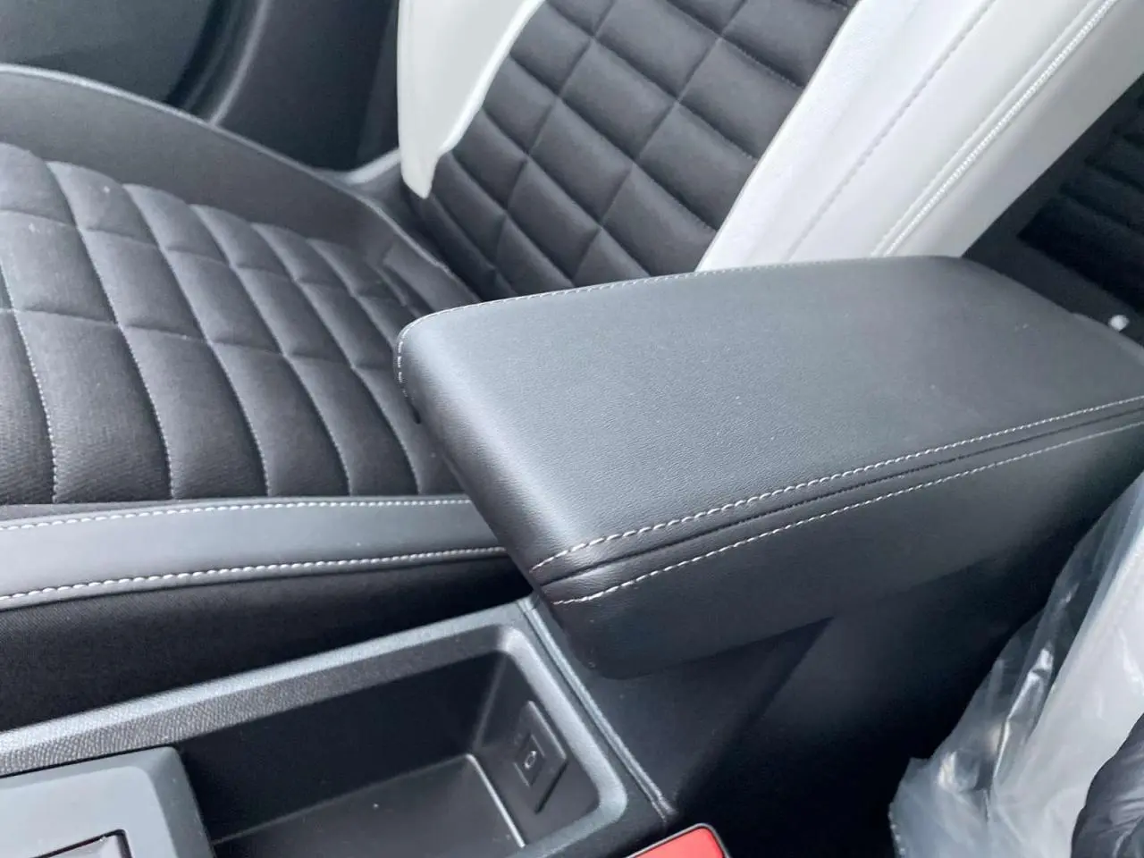 Accoudoir central noir et siège avant en tissu matelassé gris clair et noir dans le Citroën C3 Aircross 2025.