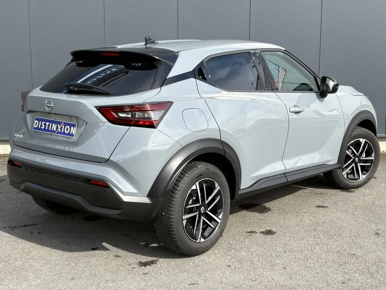 Nissan Juke gris Ceramic en 3/4 arrière droit, avec jantes noires et toit contrasté noir brillant.